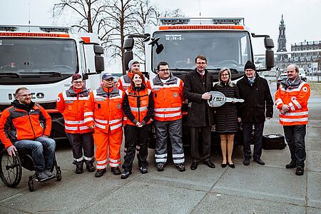 Der Sächsische Minister den Innern übergibt symbolisch einen großen Schlüssel an die anwesenden Personen des Katastrophenschutzes.